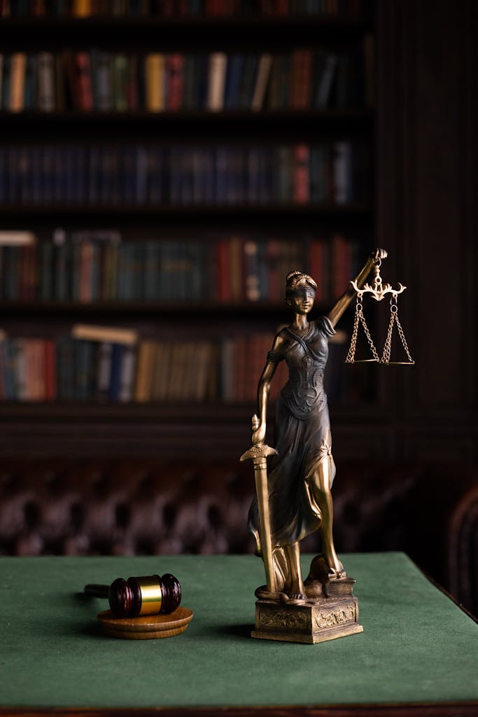 The Home of The Global Association of One Percenters 7 Lady Justice and gavel on a table in a classic law library setting.