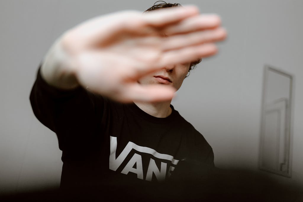 The Home of The Global Association of One Percenters 5 Young man indoors with hand covering face, creating a contemporary and casual mood. for shield at the Global Association of One Percenters
