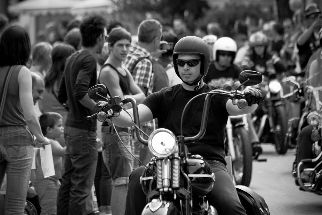 Monochrome photo of a motorcyclist in a crowd at a parade. for volunteer page